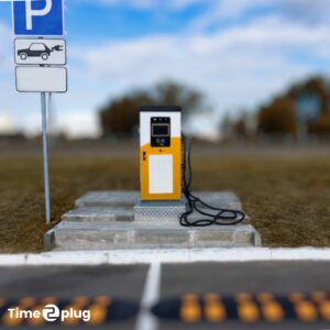 Borne de recharge électrique installée sur un site industriel, avec marquage au sol et panneau de signalisation pour véhicules électriques.